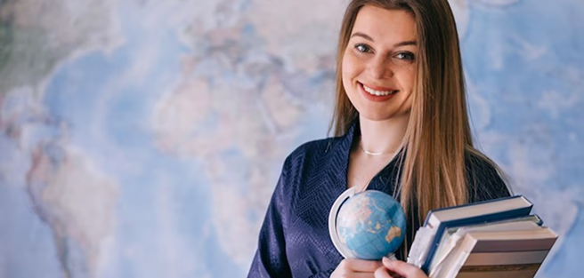 Student holding books and globe